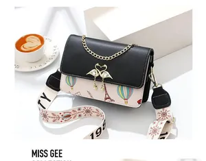 Détail du sac bandoulière imprimé avec fermoir cygne doré et sangle jacquard