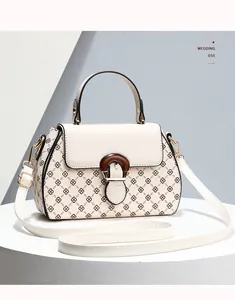 Detail view of floral print beige crossbody bag with vintage wood grain round buckle