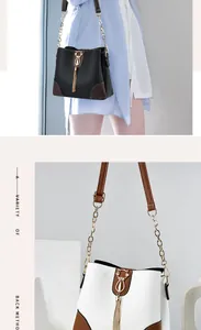Detail view of bucket bag featuring golden cat-shaped hardware and elegant metal tassels