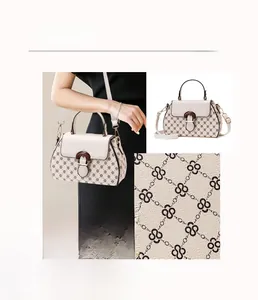 Detail showing durable fabric with geometric print and metallic chain on the beige handbag