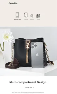 Detailed view of black bucket bag with brown trim and cute gold cat tassel charm
