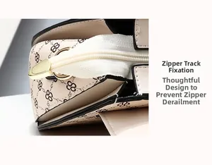 Detail view of the secure zipper end closure on a printed beige fashion handbag