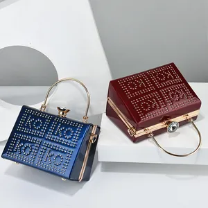 Detail of luxury glossy evening bags with metal ring handles and rhinestone clasps
