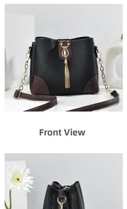Detail of crossbody bucket bag with golden cat-shaped clasp and metal tassel charm