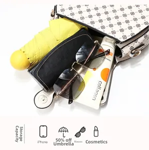 Top view of large capacity white patterned handbag holding a phone, umbrella, and makeup