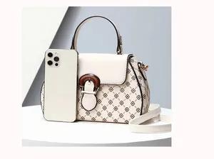Detail of printed crossbody bag with wooden buckle and smartphone for size reference