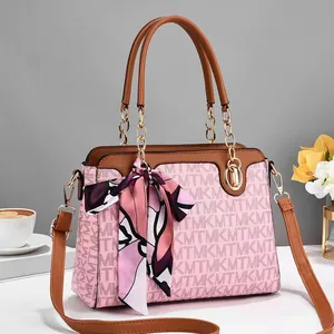 Detailaufnahme der rosa Monogramm-Handtasche mit Seidenschal und Goldketten-Akzenten