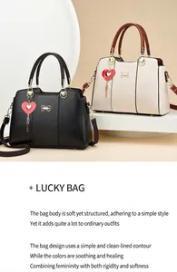 Close-up of textured leather handbag with gold bow hardware and heart-shaped pendant