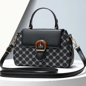 Elegant black handbag with white clover print and gold clasp for women, single handle style