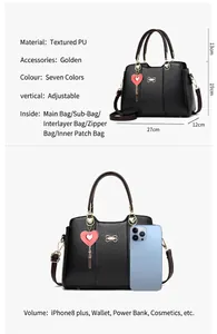 Detail view of black PU leather handbag with gold hardware, charms, and interior pockets