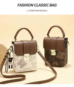 Detailed view of mini square crossbody bags with letter prints and metallic handles
