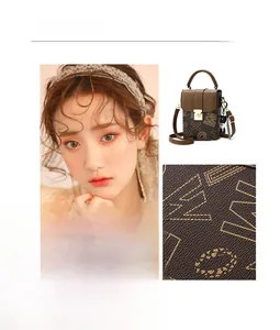 Close-up of brown letter-printed crossbody bag with gold lock and cute bear charm