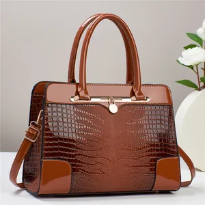 Braune Boston-Tasche mit Krokodilprägung, goldenen Beschlägen und einem Schultergurt