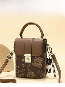 Close-up of brown vintage mini square bag with letter print and golden metal lock