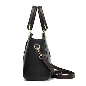 Elegante borsa in pelle bicolore nera e marrone con finiture dorate e doppi manici