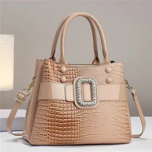 Detalle del bolso color albaricoque con textura de lagarto y hebilla de diamantes de imitación