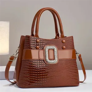 Bolso patchwork marrón con textura de lagarto, cuero brillante y hebilla strass