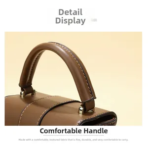 Detail of soft leather handle and precise stitching on dark brown crossbody bag