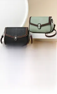 Detail view of stylish crossbody bags with crocodile pattern textures and metal locks