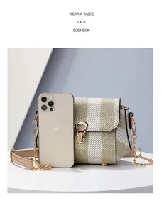 Détail de la bandoulière avec fermoir doré, chaîne et référence de taille avec téléphone