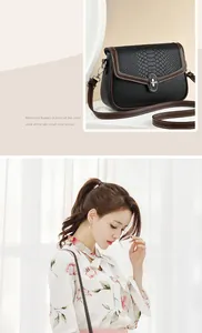 Detail view of stylish crossbody bag with black snakeskin texture and metal lock buckle