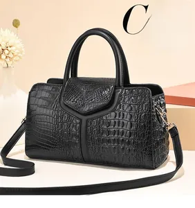 Détail de la couture motif autruche et garnitures métalliques sur le sac noir
