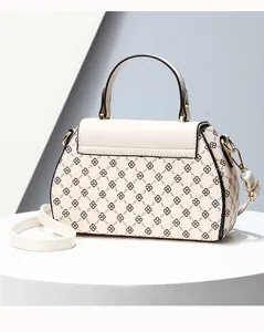 Detailed view of women's cream tote bag featuring black geometric flower pattern and gold hardware