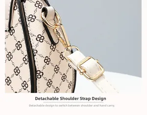Detail of golden lobster clasp and adjustable strap on a cream monogram shoulder bag