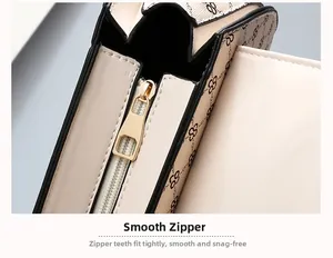 Close-up of a smooth gold zipper and printed fabric on a beige handbag