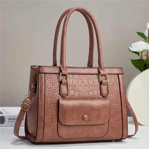 Macro detail of dusky rose handbag showing crocodile texture and gold hardware