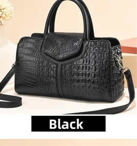 Détail du sac à main noir à motif autruche avec poignées et bandoulière réglable