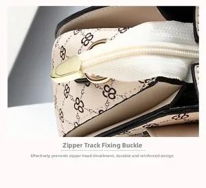 Detailed macro of the durable light-gold zipper end fastener on a patterned handbag
