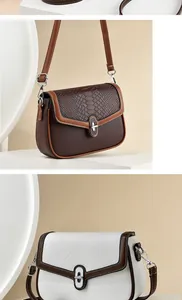 Detail of crossbody bag showing crocodile texture flap and silver metal twist lock