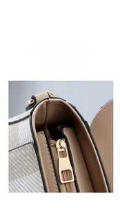 Détail de la fermeture éclair dorée à double sens sur un sac bandoulière rayé
