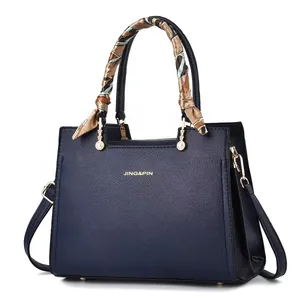 Borsa a mano blu scuro in finta pelle con foulard colorato e dettagli in metallo dorato