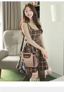 Detail der geprägten Tasche in Rosa mit Leoparden-Schal und braunen Griffen am Modell