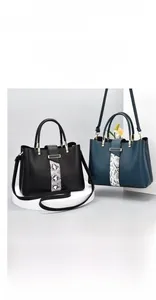 Detail of elegant tote bags featuring snakeskin textured panel and premium metal clasp
