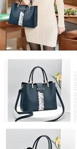 Close-up of navy blue leather handbag with snakeskin pattern and metallic buckle detail