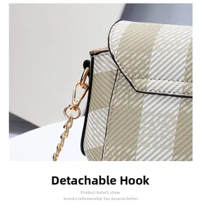 Détail du crochet doré amovible et de la chaîne sur un sac à bandoulière beige