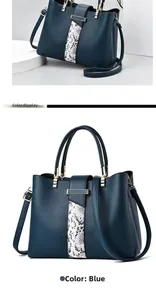 Detail view of navy blue leather handbag with snakeskin texture and adjustable strap