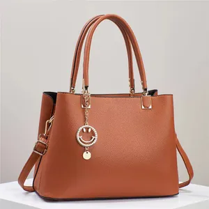 Chic brown lychee texture leather handbag with gold smiley pendant and dual handles