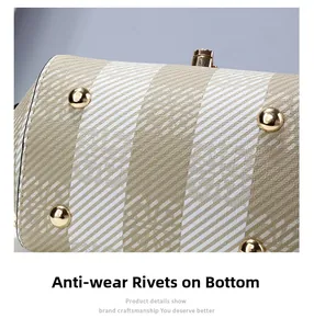 Détail du fond du sac avec rivets de protection dorés et texture en toile tissée