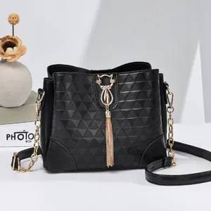 Quilted black bucket bag with gold tassel and chain strap shown in a premium studio setting