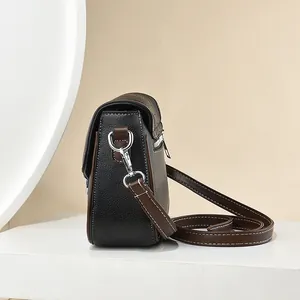 Litchi pattern black leather crossbody bag with brown trim and white stitching details