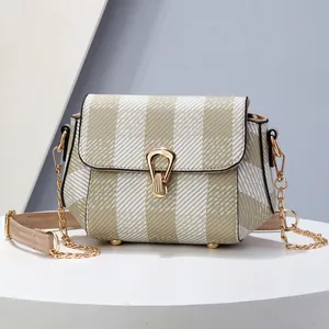 Petit sac à bandoulière rayé beige et blanc avec chaîne dorée sur présentoir