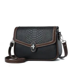 Women's crossbody bag featuring black croc-embossed leather and brown contrast trim