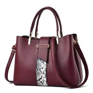 Deep burgundy leather handbag with snakeskin pattern stripes and gold hardware accents