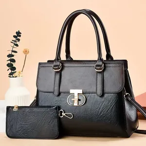 Two-piece black textured leather tote bag and pouch set with golden ring hardware details