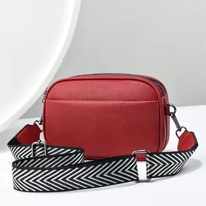 Minimalistische rote Umhängetasche mit Lychee-Muster, drei Zippern und breitem Gurt