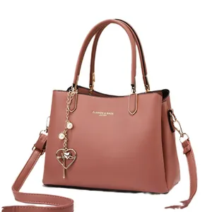 Pinkish brown leather handbag with gold lettering, heart pendant and adjustable strap